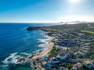 Drone shot taken above Hacienda del Mar with El Arco (Los Cabos Arch) in the distance on a sunny day