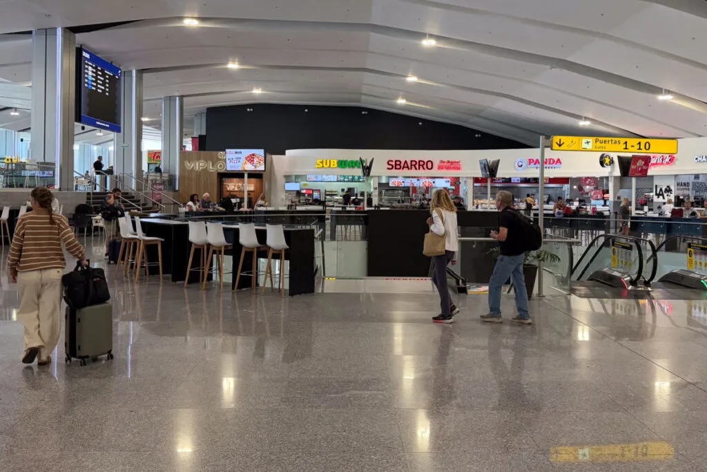 People walking in the food court in Los Cabos Airport with VIP Lounge in the photo