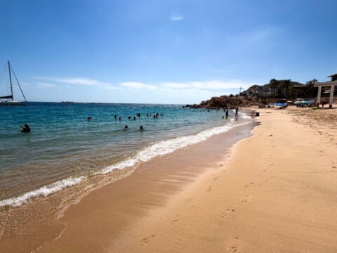 Playa Chileno Beach on a sunny day with people swimming