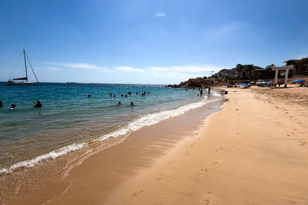 Playa Chileno Beach on a sunny day with people swimming