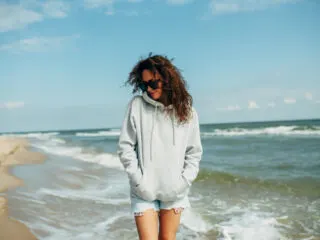 Woman in hoodie on the beach