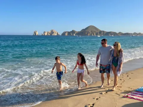 Family walking on Medano Beach in Los Cabos