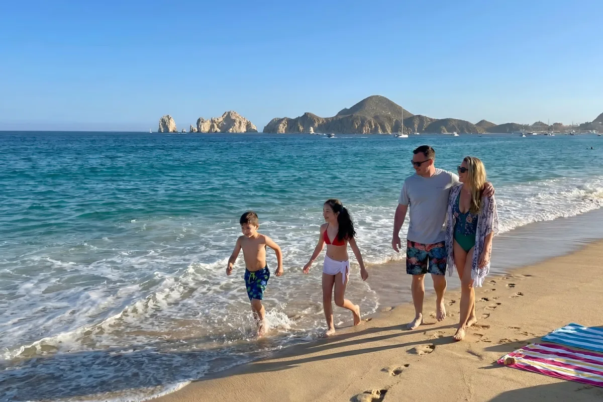 Family walking on Medano Beach in Los Cabos